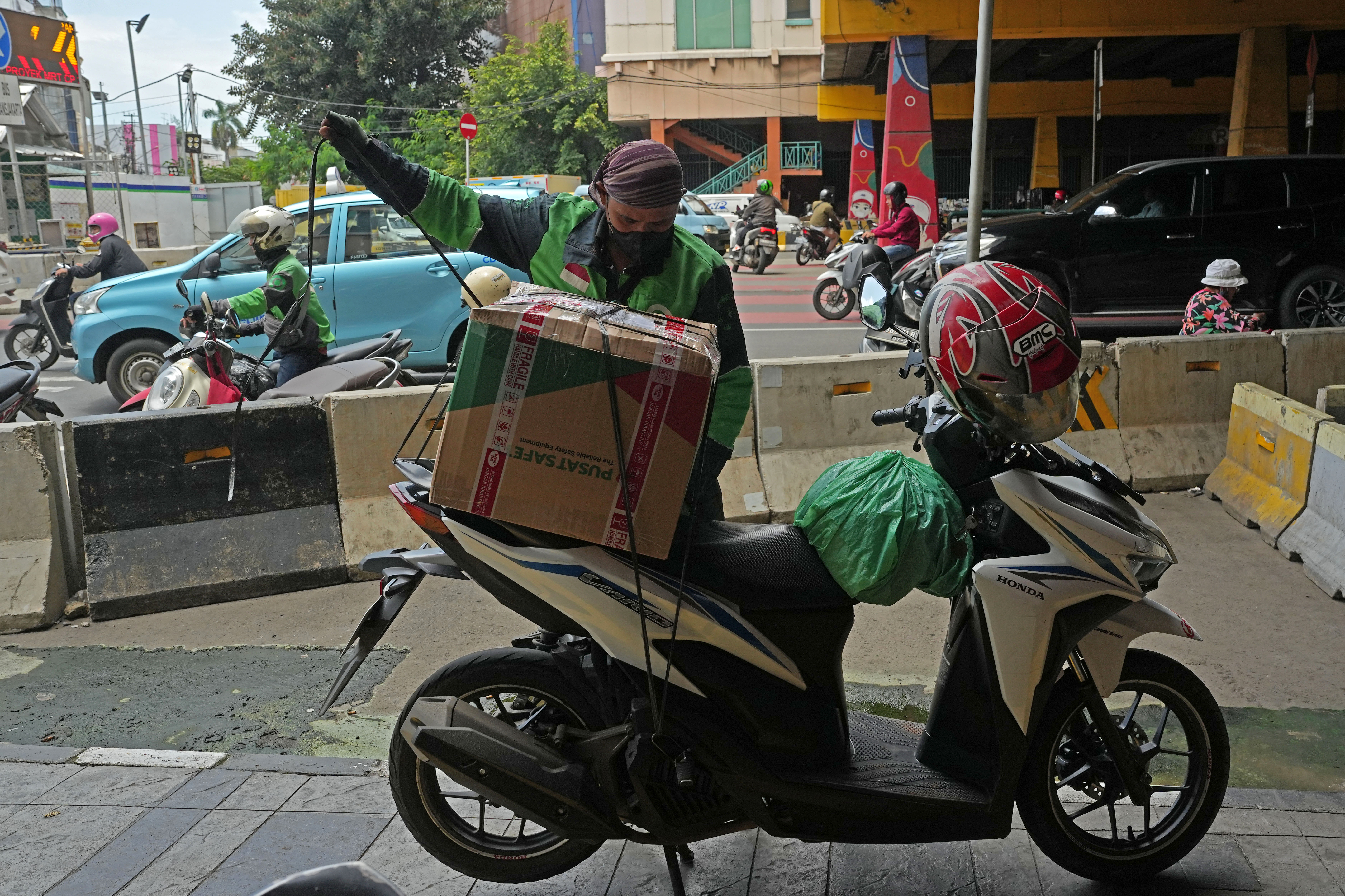 Gojek driver prepares to deliver an order in Jakarta. Photographer: Dimas Ardian/Bloomberg via Getty Images